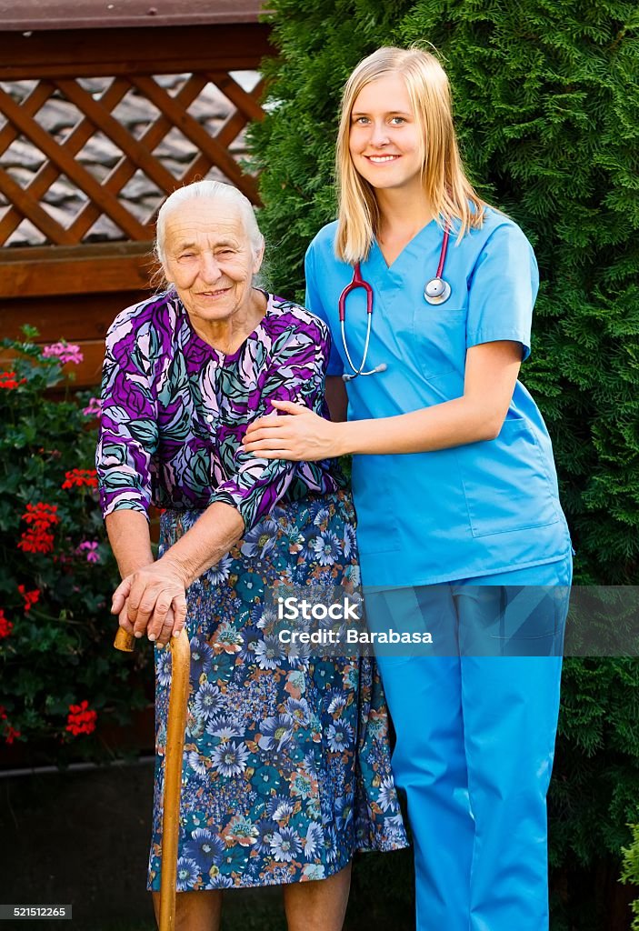 On a Walk in the Garden Elderly patient and doctor on a walk in the hospital garden. Adult Stock Photo