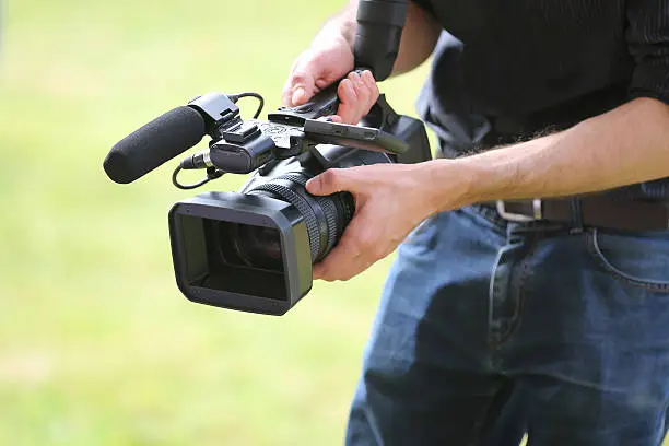 Video camera man with camera on green background