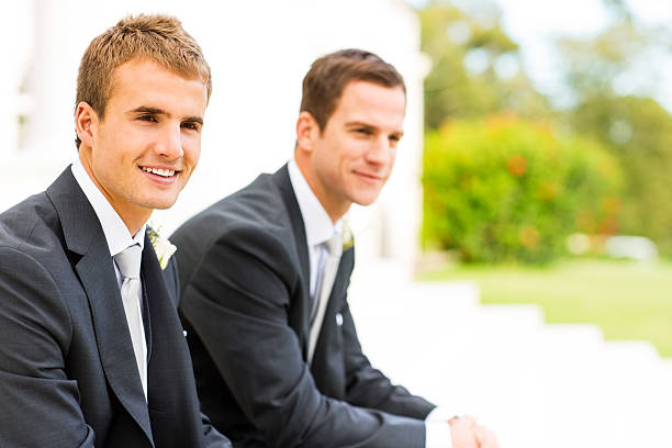 istock Best Man And Groom Looking Away While Sitting In Garden 521513061