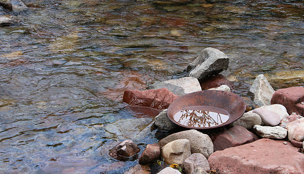 istock Rusted gold pan on rocks in a stream with water 521515433