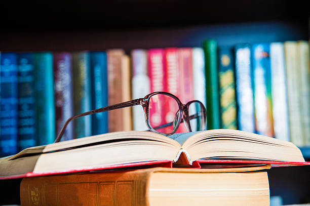 gafas y libro en fondo librería - old culture fotografías e imágenes de stock