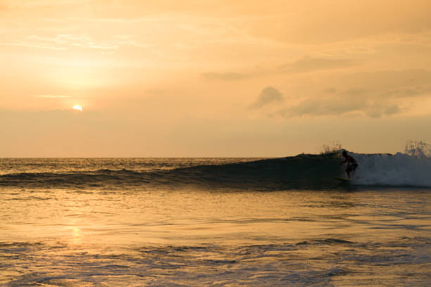 istock blured background image of surfer surfing on evning 521528260