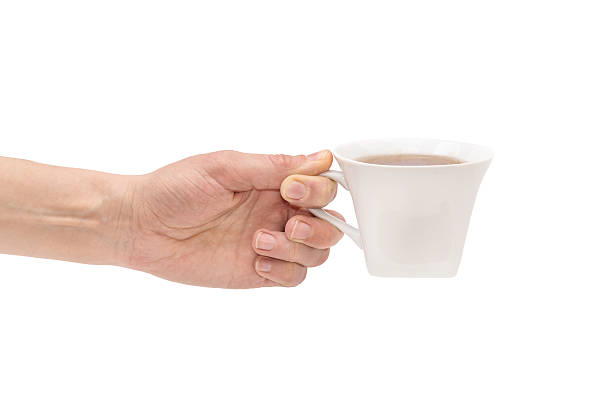 istock Hand with cup of tea isolated on white 521530406