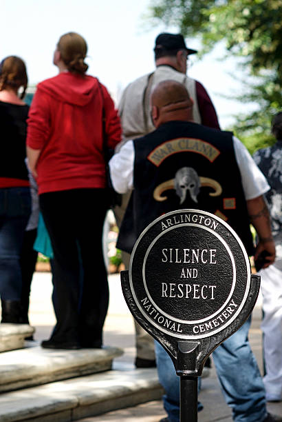 Sign "Silence and Respect", Tomb of the Unknown Soldier Arlington, Virginia, USA - May 24, 2015: A sign reminds tourists to be silent and respectful at the Tomb of the Unknown Soldier at Arlington National Cemetery as they watch a Changing of the Guard ceremony in the background. arlington cemetery in spring stock pictures, royalty-free photos & images