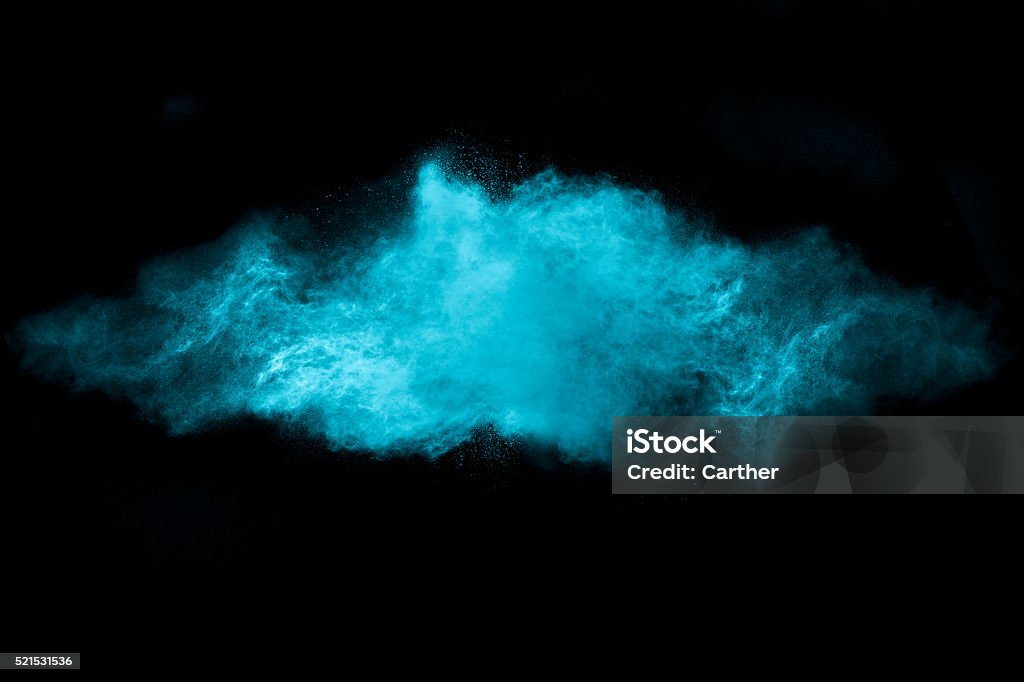 Blue Dust Particle Explosion Isolated on Black Blue dust particle explosion. Abstract design of a blue dust cloud isolated on black background Powder Snow Stock Photo