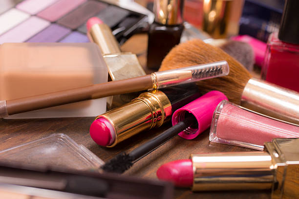 istock Pile of various cosmetics, make-up lie on wooden dressing table. 521532898