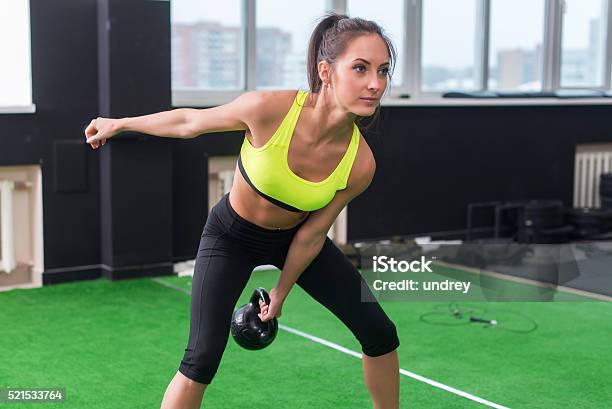 Sporty Woman Doing Workout Swinging Kettlebell In Gym Stock Photo - Download Image Now