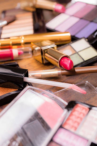 istock Pile of various cosmetics, make-up lie on wooden dressing table. 521534026
