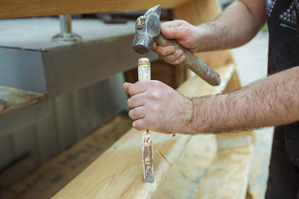 istock man working with a hammer chisel wood, men's hands 521535784