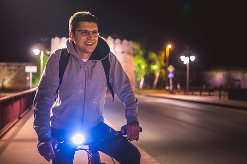 Man riding a bicycle at night the city