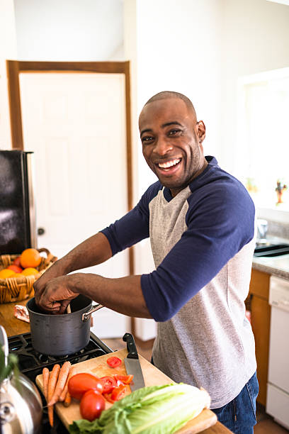 istock man standing happiness on the kitchen and preparing food 521542130