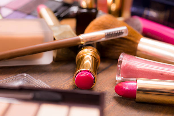 istock Pile of various cosmetics, make-up lie on wooden dressing table. 521542776