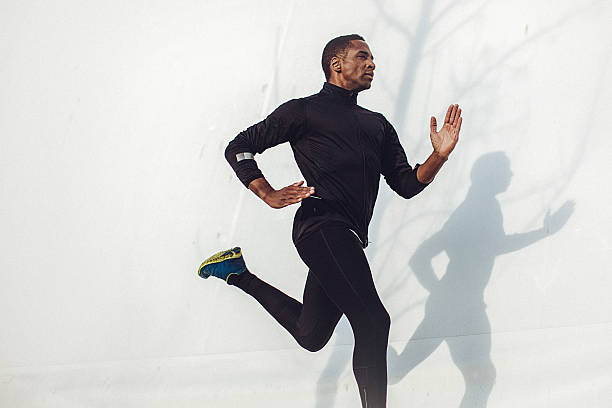 istock Young fit man running beside the white wall 521544376