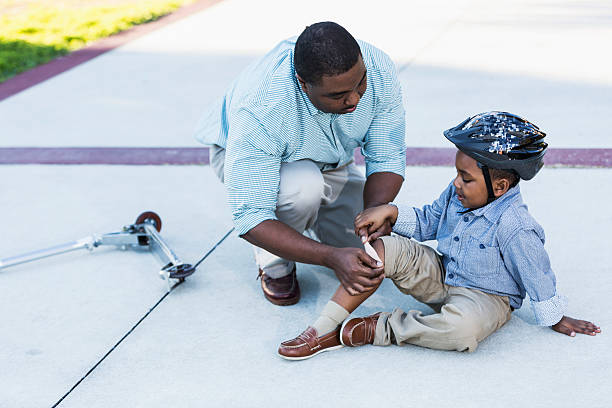 istock African American father putting bandage on son's knee 521545764