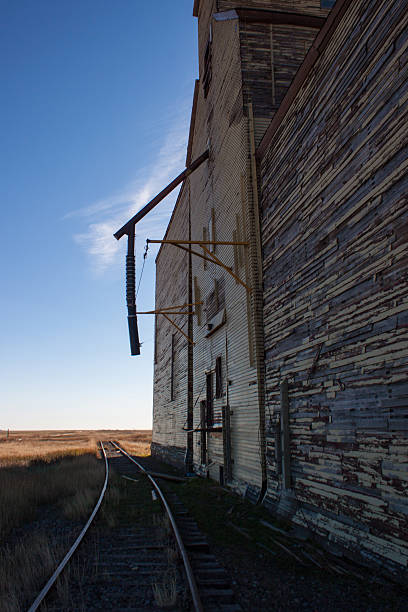 istock Side view of an old wooden grain elevator and track. 521548938