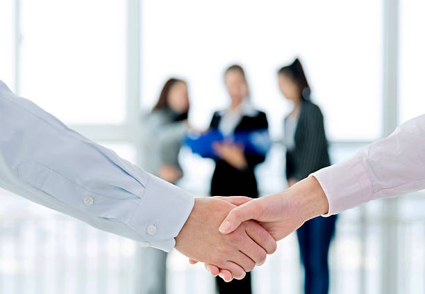istock Businesspeople shaking hands closeup 521549452