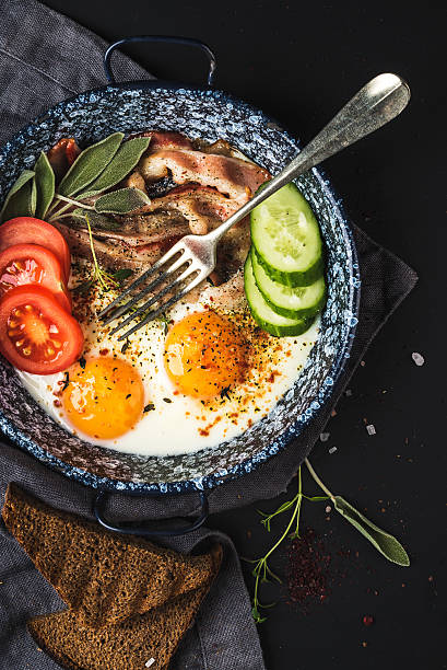 istock Breakfast set. Pan of fried eggs with bacon, fresh tomato 521550466