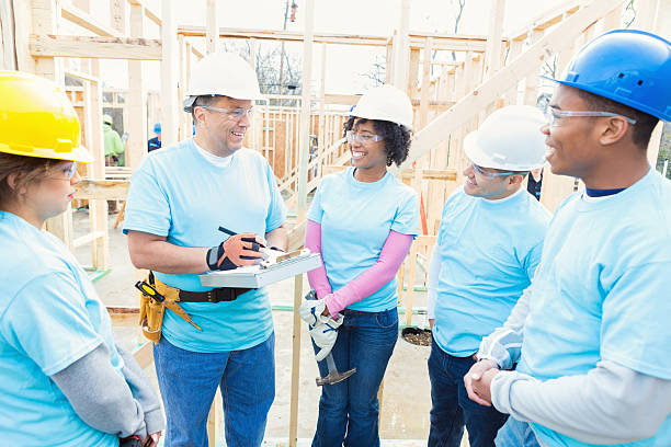 istock Construction manager meets with volunteers at worksite 521550786