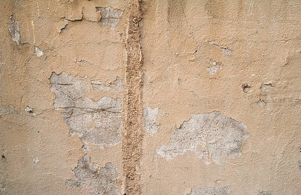 istock Texture of old wall covered with yellow stucco 521574093