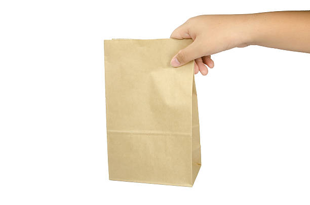 istock Boy holding a brown paper bag in his hand. 521574201