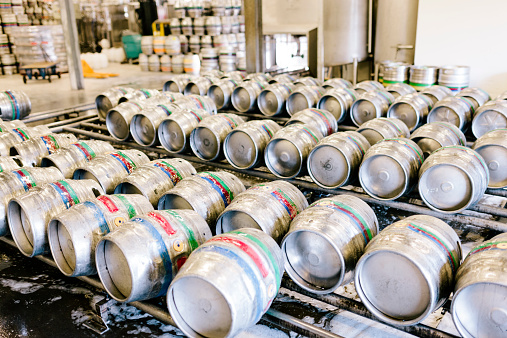 Rows of aluminium beer kegs ready for distribution at a traditional Devon brewery warehouse, Otter Brewery, Ottery St. Mary, Devon, UK