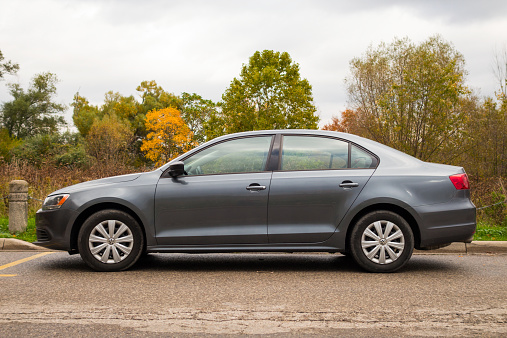 Hamilton, Canada - October 20, 2014: Dark gray colored Volkswagen Jetta family sedan parked on a street.