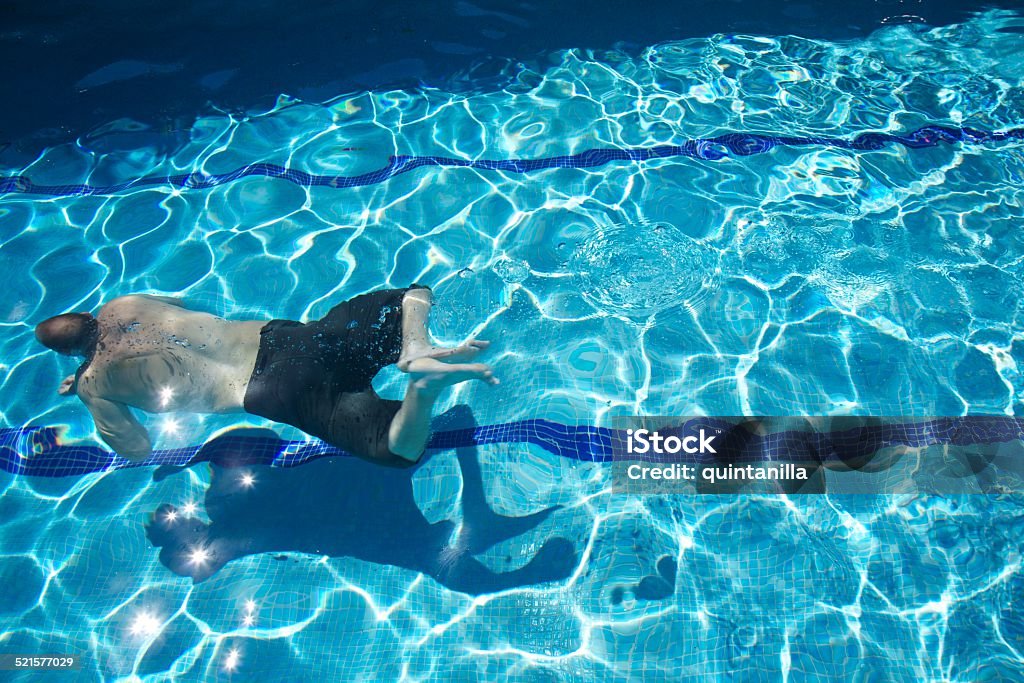 man swimming man with swimsuit swimming on a blue water pool Active Lifestyle Stock Photo