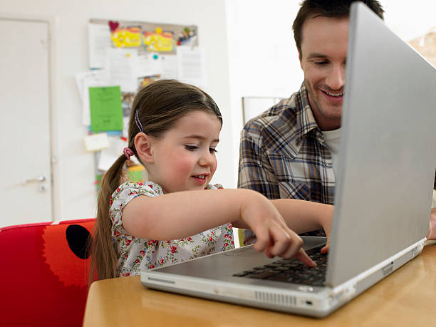 istock Girl And Father Using Laptop At Table 521579959