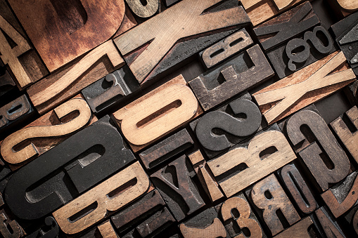 Random letterpress block letters stacked together with studio lighting forming a useful background