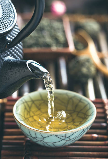 istock Pouring green tea vertical closeup 521603780