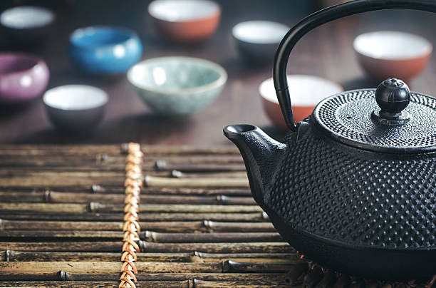 istock Traditional oriental teapot on bamboo placemat 521603794