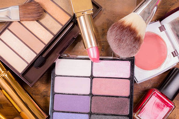 istock Pile of various cosmetics, make-up lie on wooden dressing table. 521606178