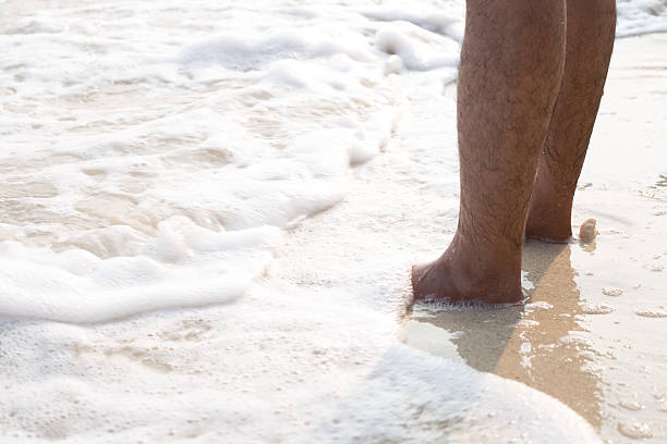 acercamiento de un hombre desnudo cuadrados un en la playa - barefoot behavior toned image close up fotografías e imágenes de stock