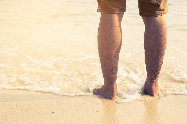 acercamiento de un hombre desnudo cuadrados un en la playa - barefoot behavior toned image close up fotografías e imágenes de stock