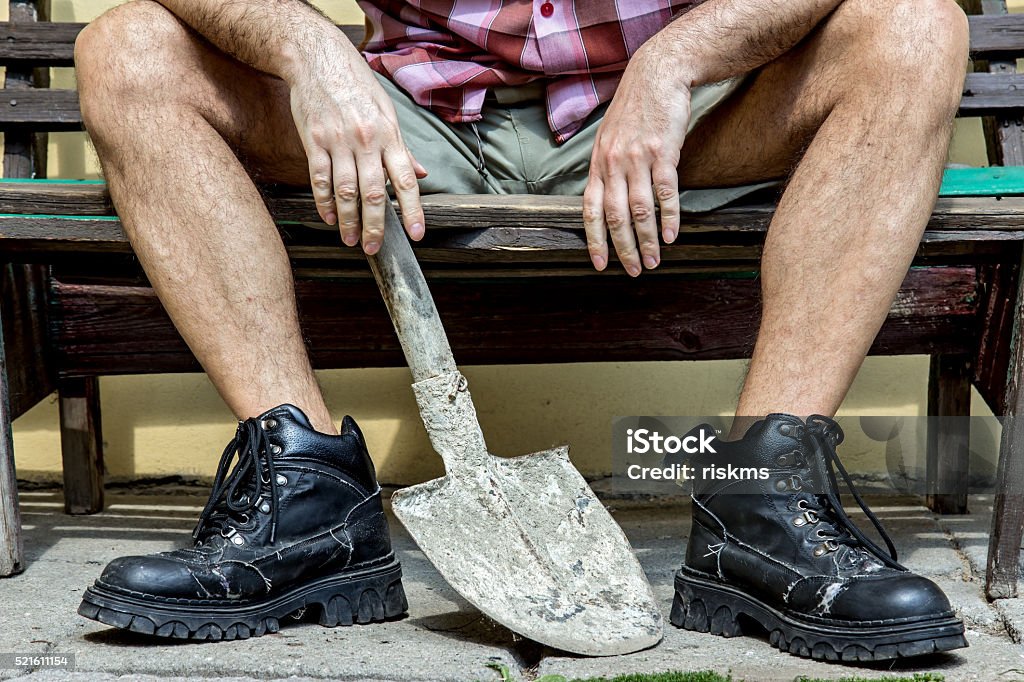 mason with hairy legs in boots resting on a bench Construction Worker Stock Photo