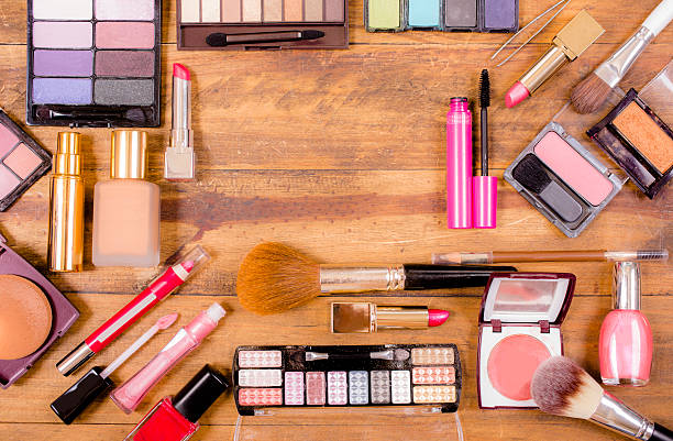 istock Pile of various cosmetics, make-up lie on wooden dressing table. 521611518