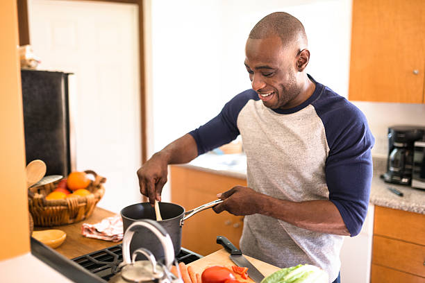 istock man standing happiness on the kitchen and preparing food 521614808