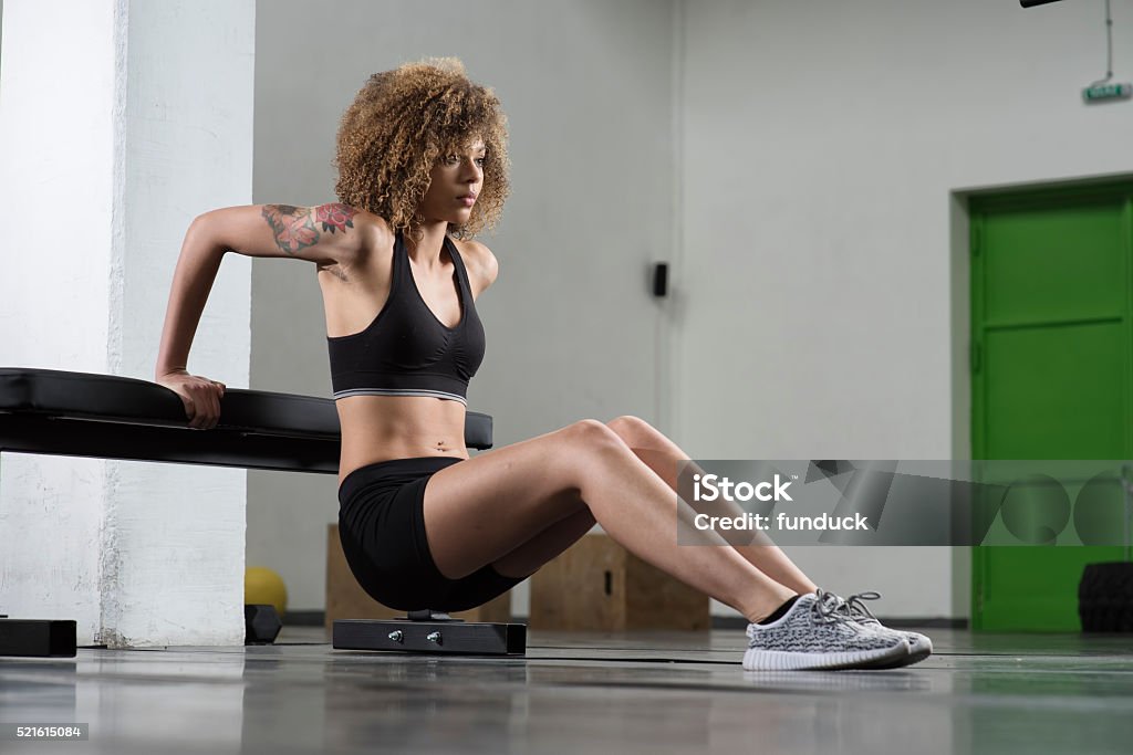 Girl working out on the bench at the gym Side view of young mixed race girl working out at the gym Abdominal Muscle Stock Photo