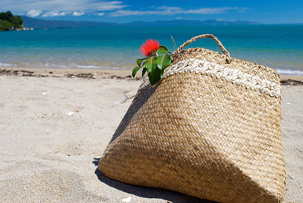 A Kiwiana Christmas background with all the elements for a Summer Holiday or Christmas background. The Kete bag is what Kiwis grab for a day at the beach and the iconic Pohutakawa which flowers just in time for the Christmas holidays;  just abandoned by the turquoise waters of the Tasman Sea.