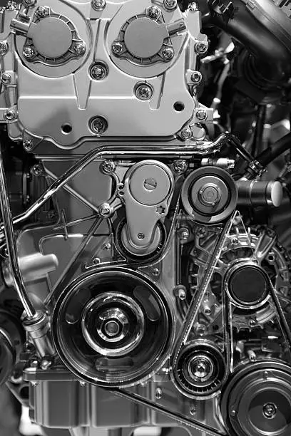 Vertical cropped shot of car engine with belts and wheels