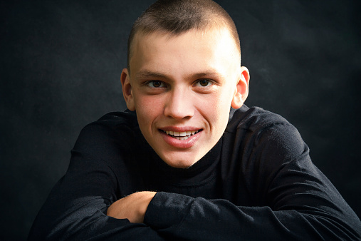 Close-up of the young man in the black clothes, smiling