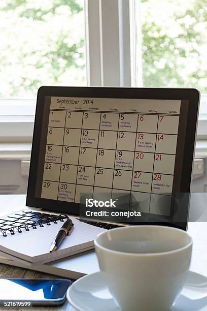 Checking Monthly Activities In The Calendar In The Laptop Stock Photo - Download Image Now