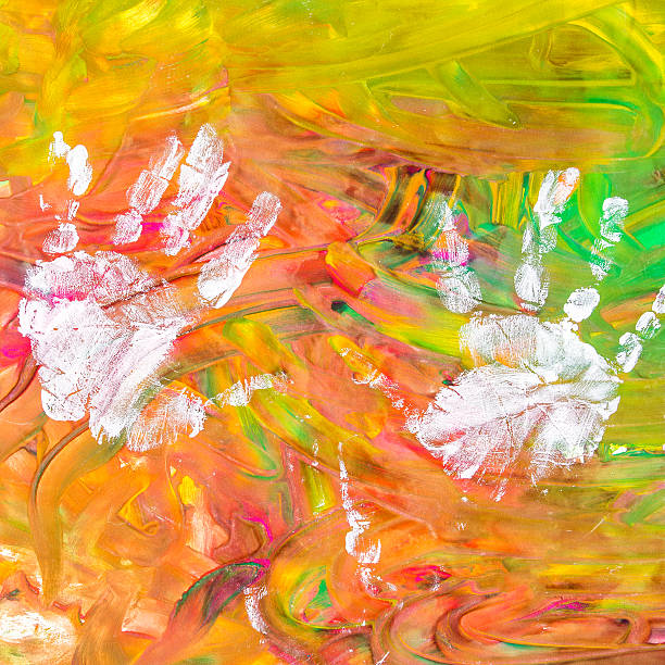 istock Child drawing painting with his white hands on colorful background 521620156