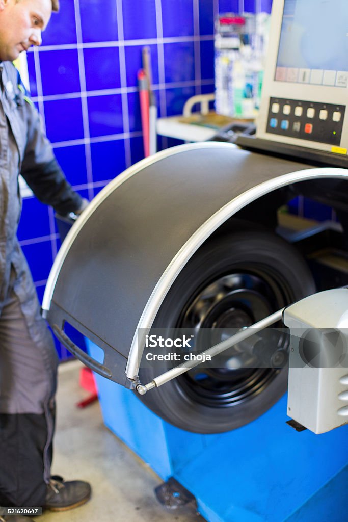 Auto mechanic is changin tire...prepairing car for winter Alloy Wheel Stock Photo