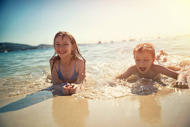 istock Brother and sister having fun in waves 521621838