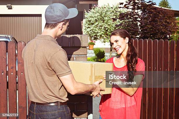 Delivery Man Delivering A Parcel For Young Woman Stock Photo - Download Image Now - 20-24 Years, Adult, Adults Only
