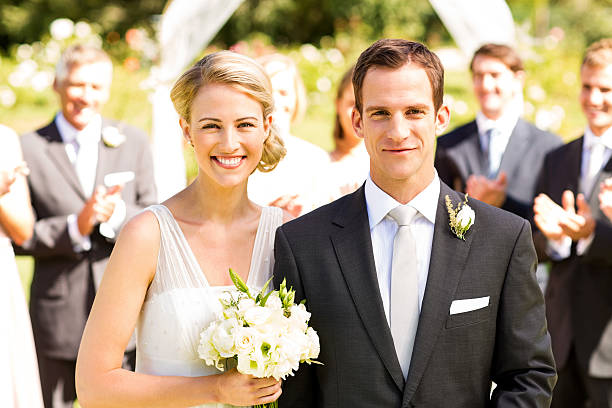 istock Newlywed Couple With Wedding Guests Clapping In Background 521622791