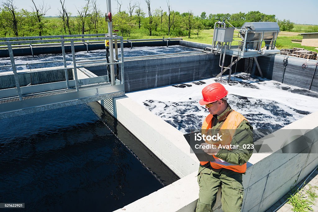 Waste water An engineer controlling the quality of water , aerated activated sludge tank at a waste water treatment plant .Copy space Sewage Treatment Plant Stock Photo