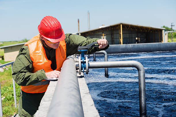 Waste water An engineer controlling the quality of water , aerated activated sludge tank at a waste water treatment plant .Copy space sewage stock pictures, royalty-free photos & images
