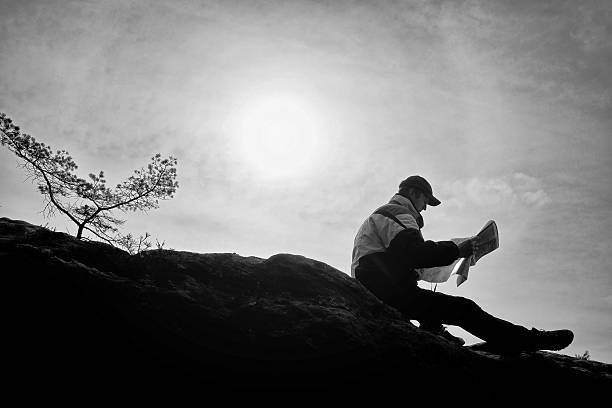 istock Silhouette of man looking at map in nature while hiking 521623268
